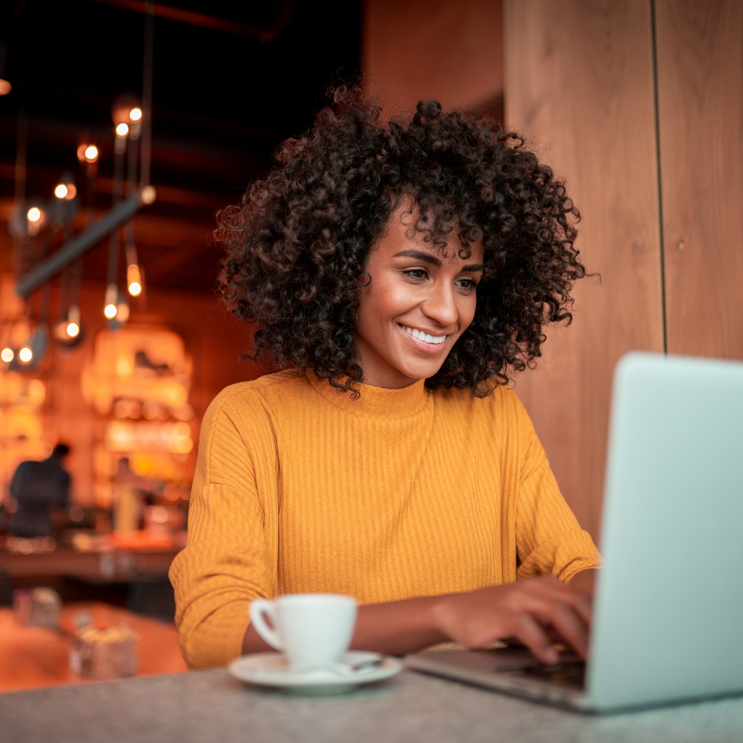 student sitting at table typing on laptop